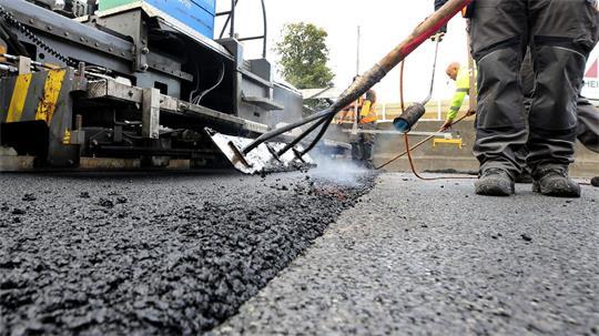 Auf einem Teilstück der Straße Ostfeld in Jork wird die Asphaltdeckschicht erneuert. (Symbolbild)