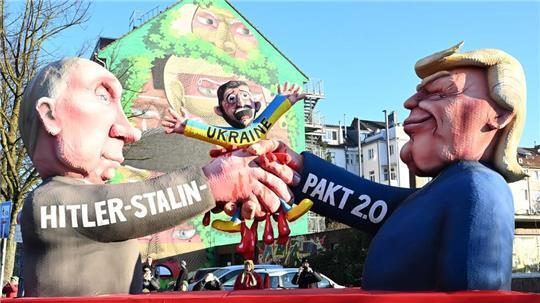 Auf einem der Düsseldorfer Rosenmontagswagen schließen Donald Trump und Wladimir Putin einen „Hitler-Stalin-Pakt 2.0“ auf Kosten der Ukraine ab. 