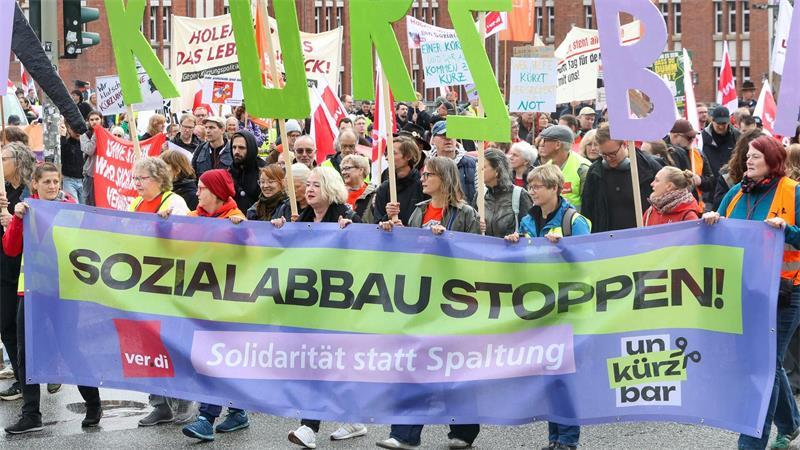 Auf einem der Transparente fordern die Demonstranten „Sozialabbau stoppen“