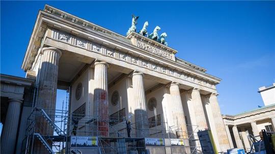 Auf einer Seite des Brandenburger Tors wird ein Baugerüst aufgebaut, um die Folgen der Farbattacke zu beseitigen.