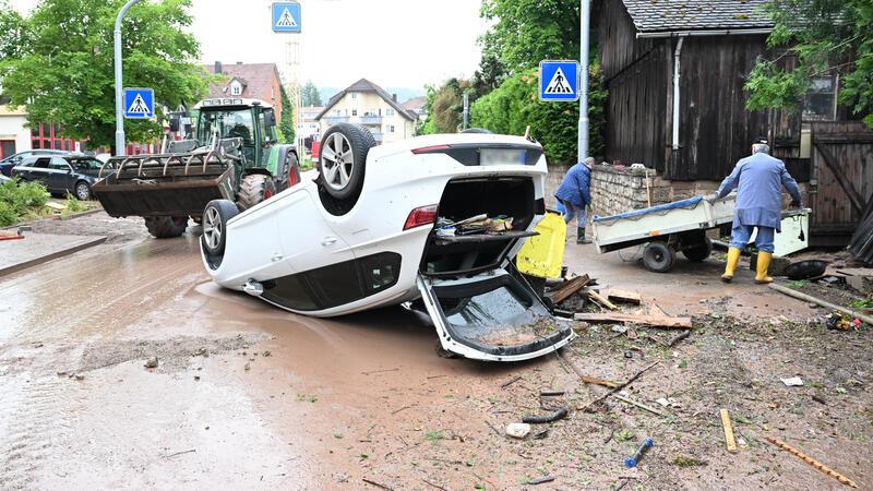 Hochwasser in Süddeutschland: So ist die Lage Auf einer Straße in Rudersberg (Baden-Württemberg) liegt ein durch ein Hochwasser umgestürztes Auto auf dem Dach.