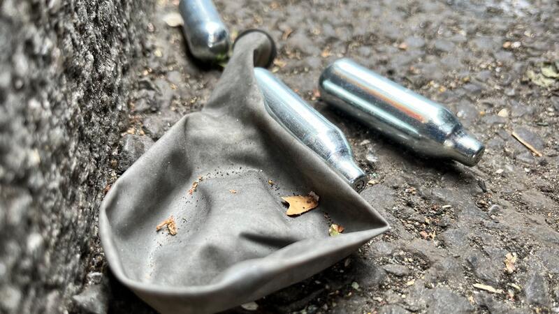 Ärztekammer fordert Verbot von Lachgas-Verkauf an Minderjährige Auf einer Straße liegen mehrere Gaspatronen und ein Luftballon.