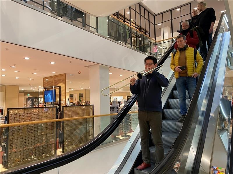 Auf einmal spielt ein Posaunist auf der Rolltreppe im Stackmann.
