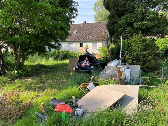 Auf seinem Grundstück und auf dem kreiseigenen Seitenstreifen der Kreisstraße 34 hat der „Axtmann“ nicht nur Müll verteilt, sondern auch Stacheldraht gespannt (rechts über dem Einkaufswagen). Foto: Vasel
