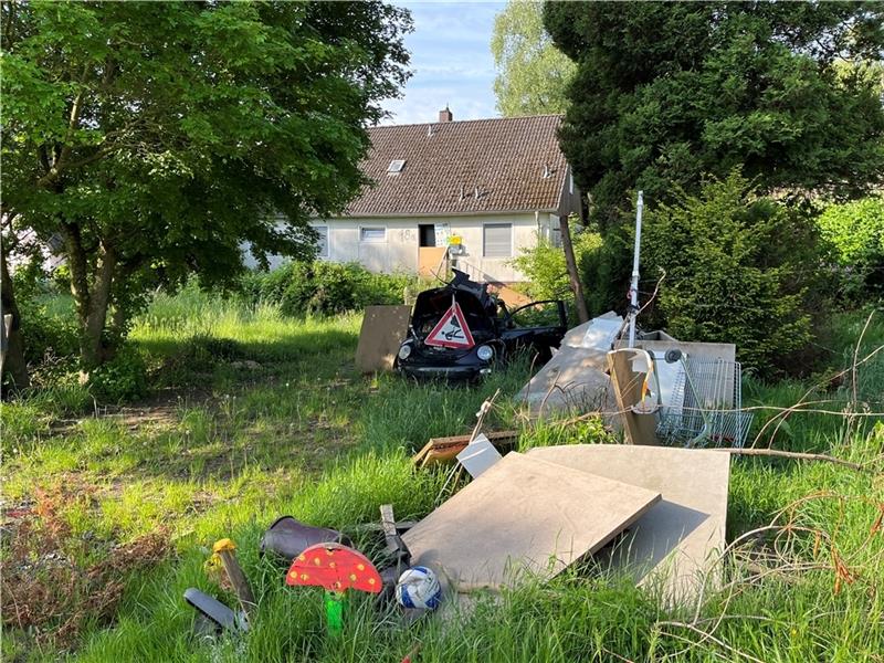 Auf seinem Grundstück und auf dem kreiseigenen Seitenstreifen der Kreisstraße 34 hat der „Axtmann“ nicht nur Müll verteilt, sondern auch Stacheldraht gespannt (rechts über dem Einkaufswagen). Foto: Vasel