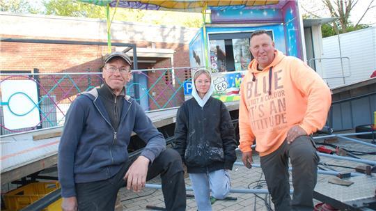 Aufbau des Nightdancers in Harsefeld: Die Schaustellerfamilie Schwenk mit Roman Brüel (links), Tochter Viviane und Ingo Schwenk.