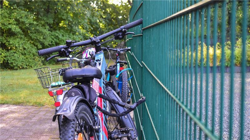 In Horneburg gefährden Elterntaxis Kinder - Anwohner von Verkehr genervt Fahrräder sin an einem grünen Zaun angekettet.
