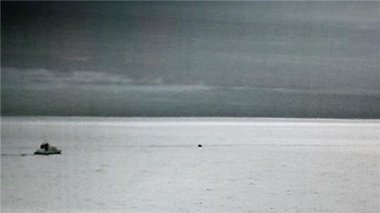 Aufnahme der bordeigenen Wärmebildkamera des Seenotrettungskreuzers "Anneliese Kramer": Der schwarze Punkt in der Mitte sind die dicht beieinander stehenden Verunglückten, links ist das Tochterboot "Mathias" zu erkennen.