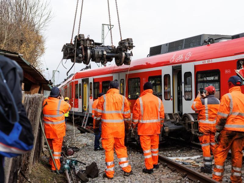 Aufräumarbeiten nach dem S-Bahn-Unfall: Das entgleiste Drehgestell hängt am Haken eines Krans. Foto: Matthias Balk/dpa