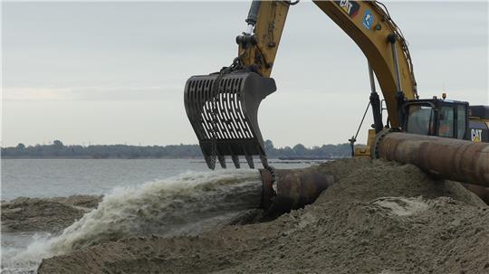 Aus der 80 Zentimeter großen Rohröffnung schießt die Sand-Wasser-Mischung auf den Krautsander Strand.