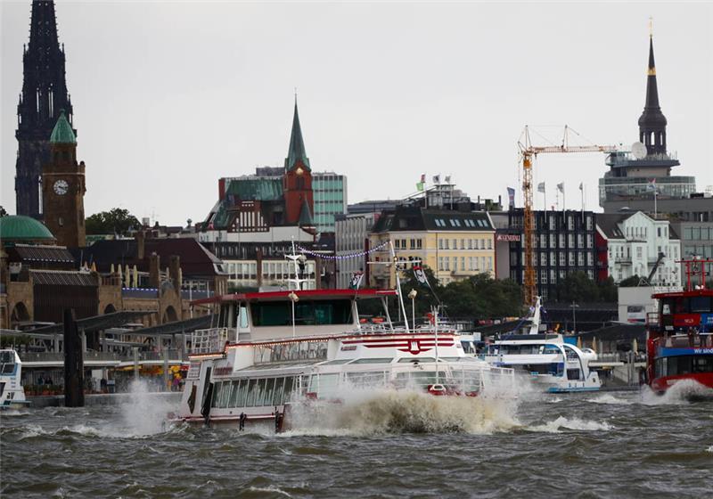 Ausflugs- und Linienschiffe sind am im Hafen von Hamburg bei starkem Gegenwind auf der Elbe vor den Landungsbrücken unterwegs. Foto: Christian Charisius/dpa