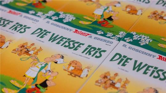 Ausgaben des neuen Asterix-Bandes mit dem Titel „Die weiße Iris“ werden in einer Logistikhalle konfektioniert und in Displays für den Einzelhandel verpackt.