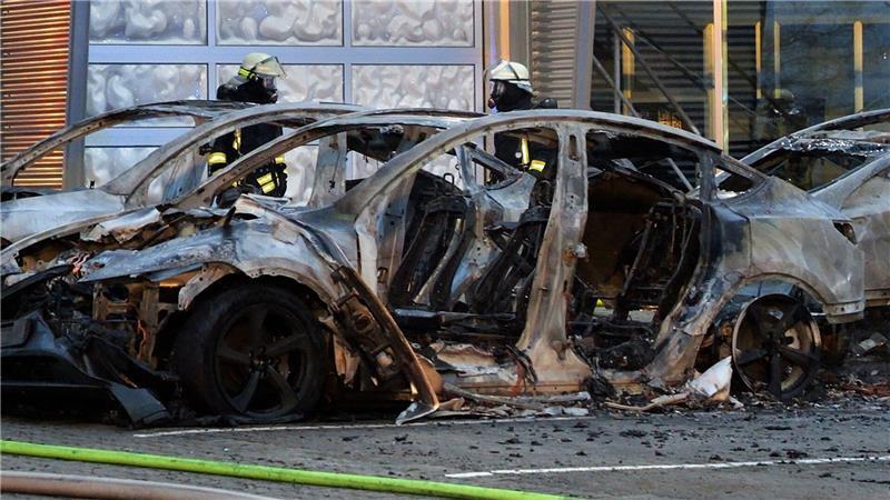 Ausgebrannte Teslas stehen vor einem Tesla-Autohaus im Landkreis Verden in Niedersachsen. Die Ursache des Feuers, bei dem mehrere Fahrzeuge zerstört wurden, war zunächst unklar.  