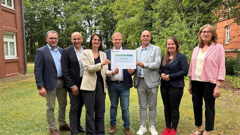 Aushändigung des „Lottogewinns" (von links): Lienhard Varoga (Amt für Regionale Landesentwicklung), Uwe-Heinz Bendig (Ministerium), Ministerin Miriam Staudte, Nils-Arne Eggert und Ernst Hülsen, Landtagsabgeordnete Corinna Lange und die Landesbeauftragte Karin Beckmann.