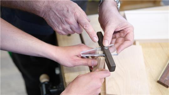 Auszubildende arbeiten in einem Klassenraum in der Gewerblichen Schule für Holztechnik an einem Werkstück. 
