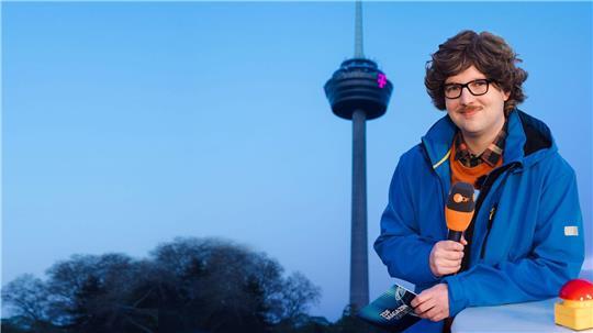 Autor Chris Sommer in seiner Rolle als Reporter Peter-Stefan Thomas vor dem Kölner Fernsehturm - das „ZDF Magazin vor Ort: Die Colonius-Sprengung“ kommt am Freitag. (Handoutbild)