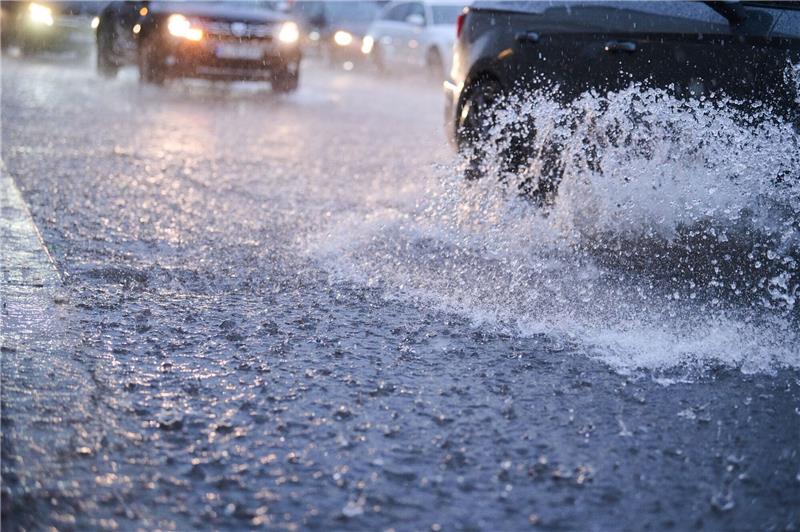91 Millionen Euro Schäden durch Starkregen in Hamburg Autos fahren bei starkem Regen durch tiefe Pfützen.