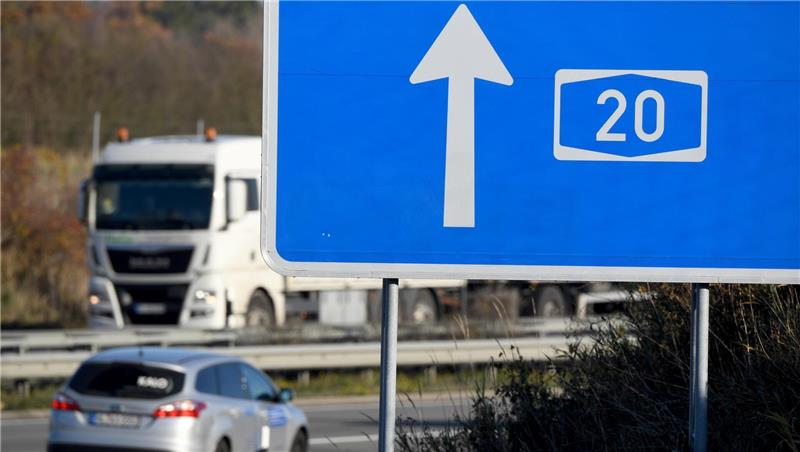 Autos fahren hinter einem Hinweisschild zur A20 auf der Autobahn. Die Autobahn soll nach dem Willen der Unterweser-Anrainer bis nach Niedersachsen ausgebaut werden. Foto: Carsten Rehder/dpa