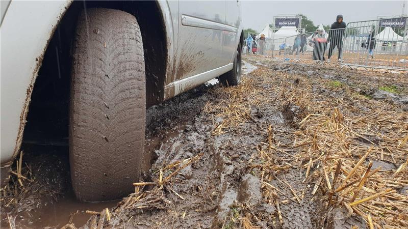 Deichbrand-Besucher flüchten vor Regen – Autos versinken im Matsch Autos fahren sich auf den Feldern des Deichbrand-Parkplatzes fest. Trecker sind im Einsatz. Foto: Overschmidt