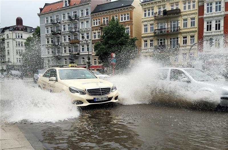 Autos kämpfen sich im Stadtteil Eppendorf nach  Starkregen durch die überfluteten Straßen. Foto: Heimken/dpa