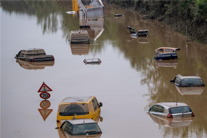 Autos stehen auf der überfluteten Bundesstraße 265 im Wasser. Die Flutkatastrophe in der Eifel und im Ahrtal im Juli 2021 wurde durch tagelange heftige Regenfälle verursacht. Foto: Marius Becker/dpa