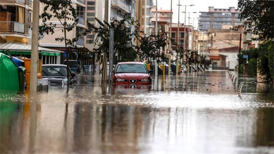 Autos stehen im Hochwasser einer überschwemmten Straße.