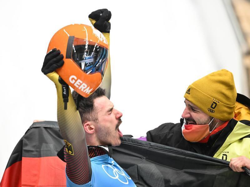 Axel Jungk (links) schreit im Ziel seine Freude heraus. Foto: Robert Michael/dpa-Zentralbild/dpa