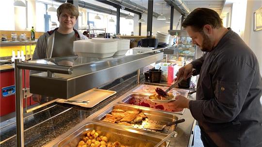 Kantinenchef Marko Weise gibt Azubi Marcel Ciesinski Pannfisch auf