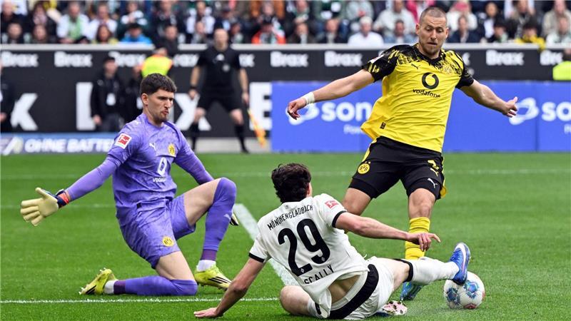 BVB-Torwart Gregor Kobel (l) und Waldemat Anton (r) im Duell mit Gladbachs Joe Scally. 