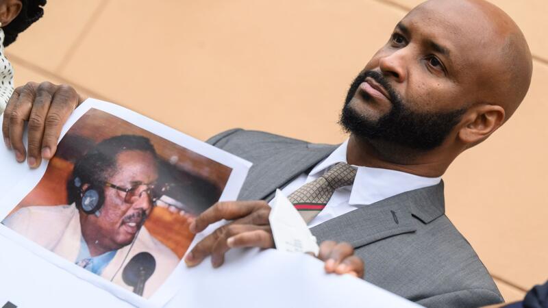 Baba Hydara, Sohn des getöteten gambischen Journalisten Deyda Hydara, steht mit einem Foto seines Vaters vor dem Oberlandesgericht Celle.