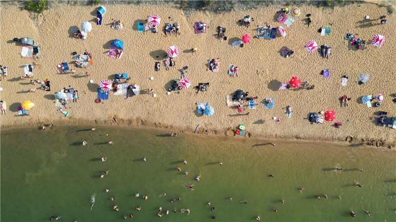 Badegäste liegen am Strand am Rather See in Köln (Luftaufnahmen mit einer Drohne).