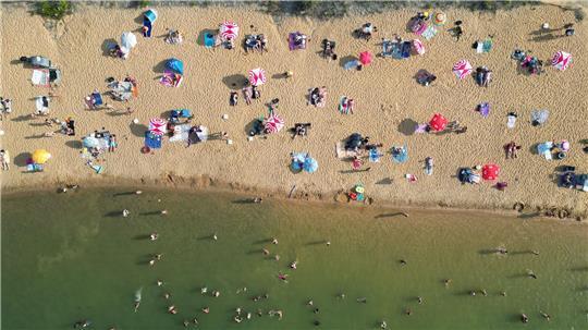 Badegäste liegen am Strand am Rather See in Köln (Luftaufnahmen mit einer Drohne).
