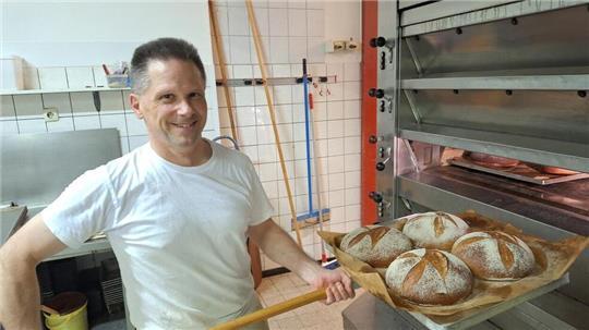 Bäckermeister Torsten Peters holt das knusprige Brot aus dem Ofen, den er morgens als erstes einschaltet.