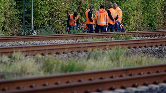 Bahn-Mitarbeiter stehen am Rand der Strecke Köln-Düsseldorf. 