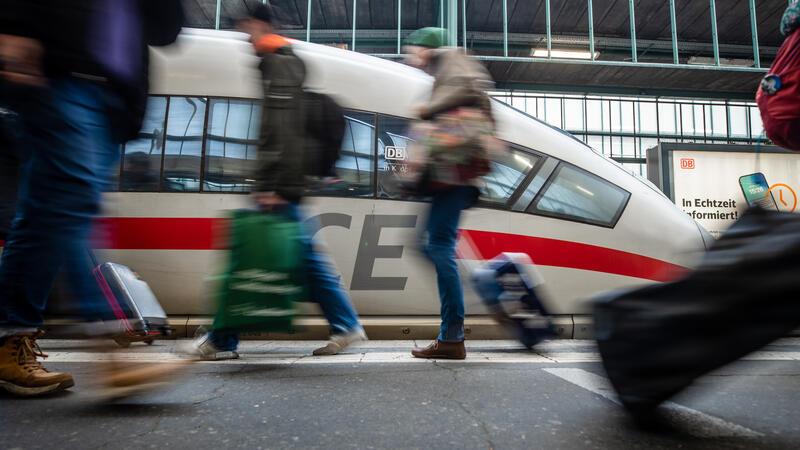 Fahrgäste laufen am letzten Schultag vor den Weihnachtsferien an einem Bahnsteig des Stuttgarter Hauptbahnhofs an einem ICE vorbei.