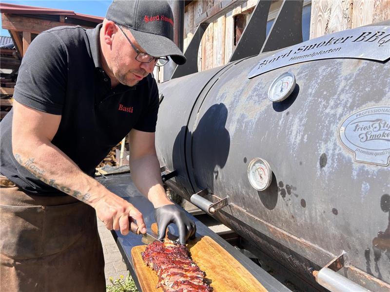 Raucharoma und Zeit: Himmelpfortener gibt Tipps fürs Grillen im Smoker Basti zerteilt die fertigen Rippchen.
