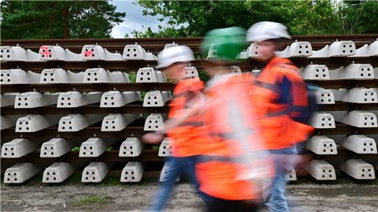 Baustellenbesucher gehen während der Generalsanierung der Bahnstrecke Hamburg - Berlin an neuen Schienen vorbei.