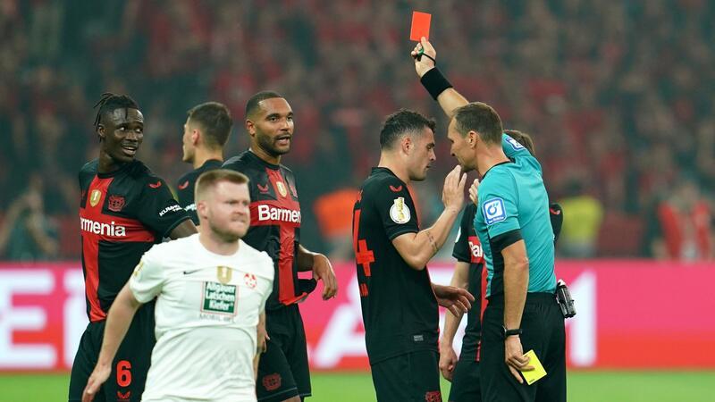 Bayer-Verteidiger Odilon Kossounou (l) sah noch vor der Pause die Gelb-Rote Karte.