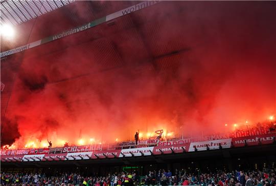 Bayern-Fans brennen auf der Tribüne Feuerwerkskörper ab. Der Club will den Gästebereich in einem Jahr verlegen. Foto: Marcus Brandt/dpa