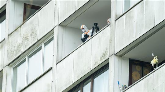 Beamte der Spurensicherung ermitteln auf einem Balkon des Hochhauses. Ein junger Mann ist in der Nacht in Hamburg-Wilsdorf vom Balkon eines Hochhauses in den Tod gestürzt.