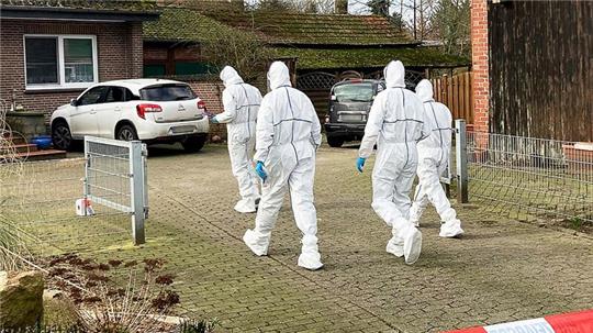 Beamte der Spurensicherung gehen zu einem Einfamilienhaus in der Gemeinde Scheeßel.