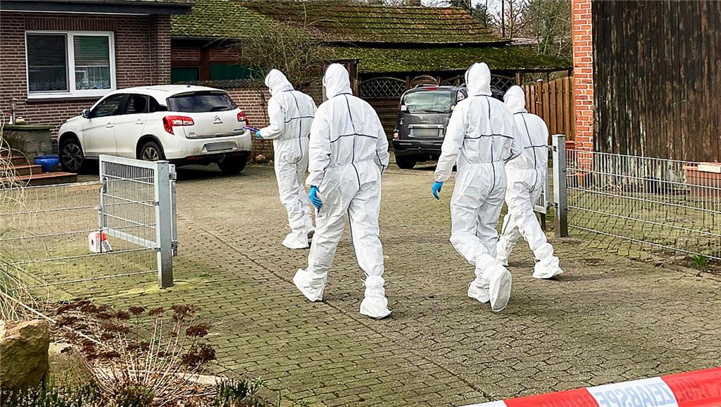 Beamte der Spurensicherung gehen zu einem Einfamilienhaus in Scheeßel. Foto: Hel...