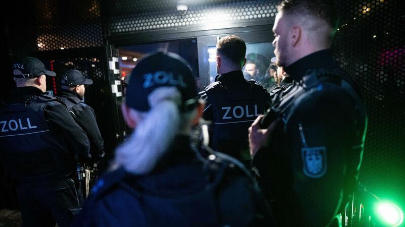 Beamte des Zoll stehen während einen Razzia vor einem Club.