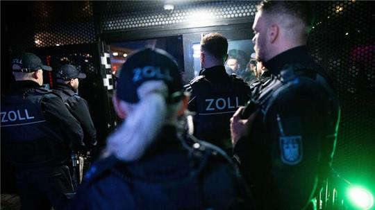 Beamte des Zoll stehen während einen Razzia vor einem Club.