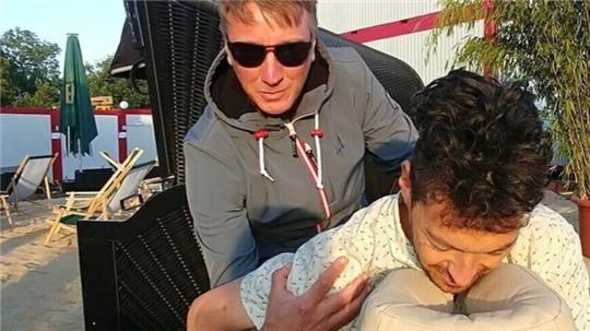 Beat Halberschmidt, Bassist von Marteria, lässt sich auf der Massage-Bank im Deichbrand-Künstlerdorf durchkneten.