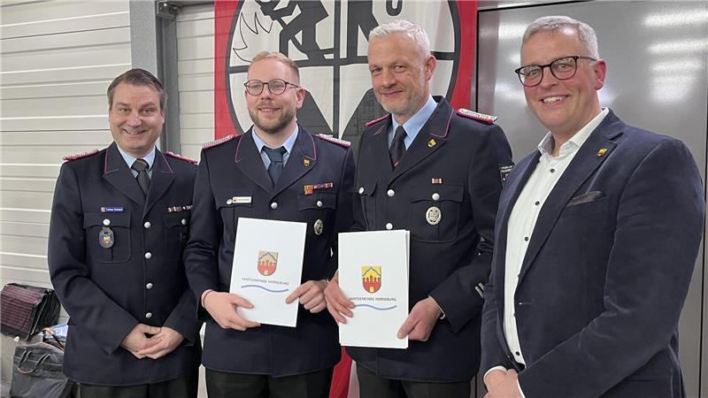 Befördert: Gemeindebrandmeister Torben Schulze und Bürgermeister Knut Willenbockel nehmen den Horneburger Ortsbrandmeister Dennis Dalchau und den Vize-Gemeindebrandmeister Niels Bründel (2. von rechts) in ihre Mitte.