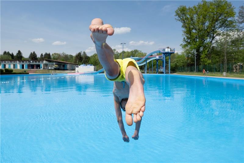 Beginn der Badesaison: Ein Junge springt im Freibad Zacke im sächsischen Freital von einem Startblock ins Wasser.