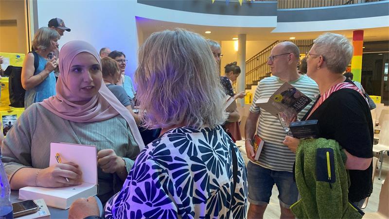 55. Buxtehuder Bulle: Spannende Auszählung und eine überglückliche Gewinnerin Bei Autorin Basma Hallak stehen etliche Schlange, um persönlich zu gratulieren und sich ihr Exemplar vom Sieger-Titel „Please Unfollow“ signieren zu lassen.