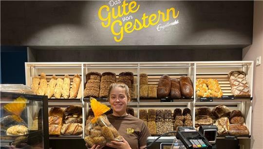 Bei „Das Gute von Gestern“ gibt es jeden Tag, außer montags, Backwaren und Kuchen vom Vortag. Die Verkäuferin Nina Andersen hält eine der beliebten Brottüten in der Hand.