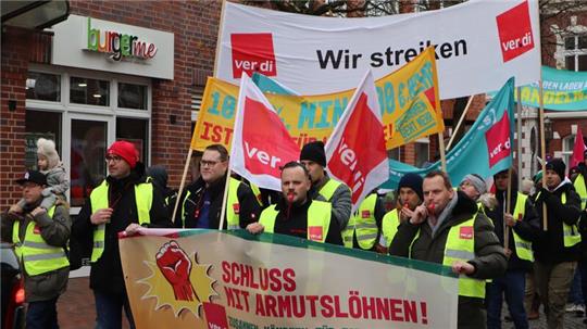 Bei Falck Fire Services beschäftigte Airbus-Werksfeuerwehrleute mit Verdi-Fahnen bei einer Demo in Stade im November 2023.